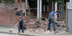 Sweeping and cleaning up in Rolleston Avenue, Christchurch City, after the big earthquake. Photograph taken 22 February 2011.